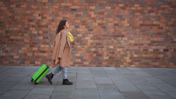 A young woman traveler going bus station with luggage.