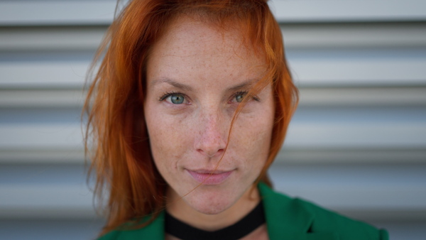 Close-up of redhead woman looking at the camera.