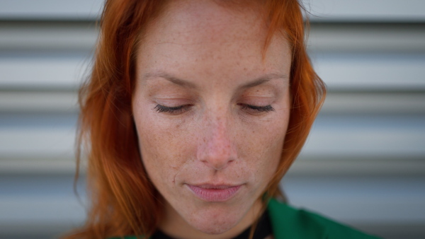 Close-up of redhead woman looking at the camera.