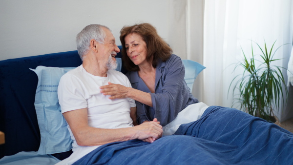 Senior couple in bed, being intimate. Morning atmosphere.