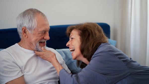 Senior couple enjoying spending time together while lying in bed, carressing each other.