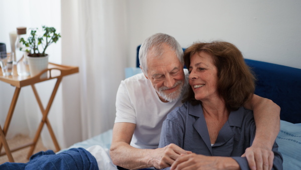 Senior couple enjoying spending time together while in bed. Morning atmosphere.