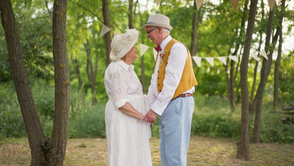 Senior couple having marriage in nature during a summer day.