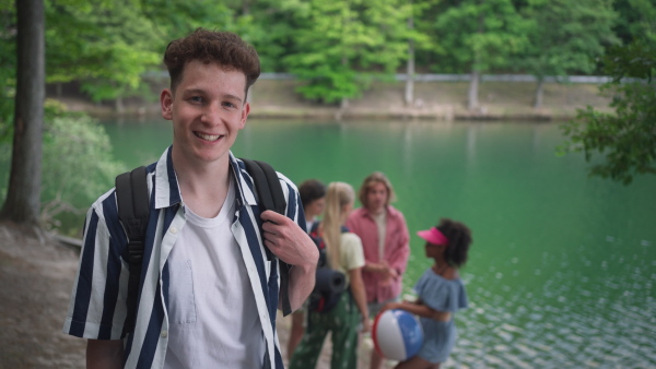 A group of young friends on camping trip near lake in summer.