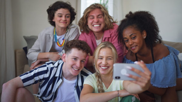 A diverse group of friends with mixed races having fun together and taking selfie indoors, Friendship and lifestyle concepts