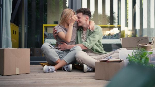 A cheerful young couple in their new apartment. Conception of moving.