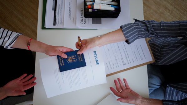 A woman holding application forms for Ukrainian refugees in asylum centre.