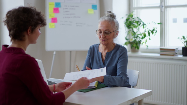 A senior woman recruiter talking to young candidate during the job interview.