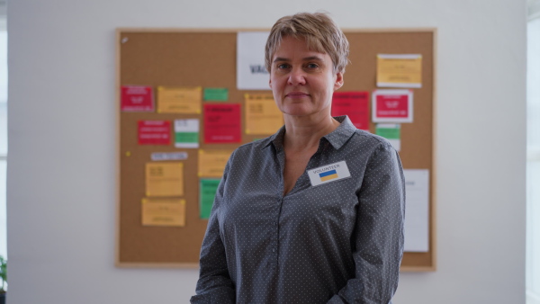 A job center employee standing in front of employment noticeboard.