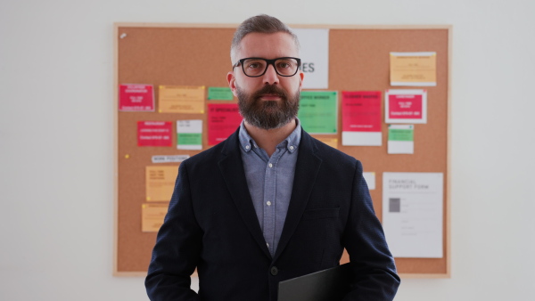 A job center employee standing in front of employment noticeboard.