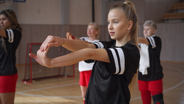 A group of young and old women, sports team players in gym, doing work out exercise.