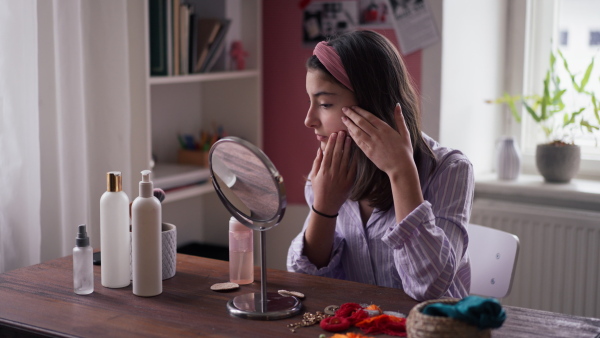 Teenage girl doing her skin care routine in the room.