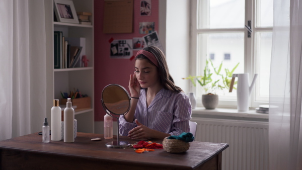 Teenage girl doing her skin care routine in the room.