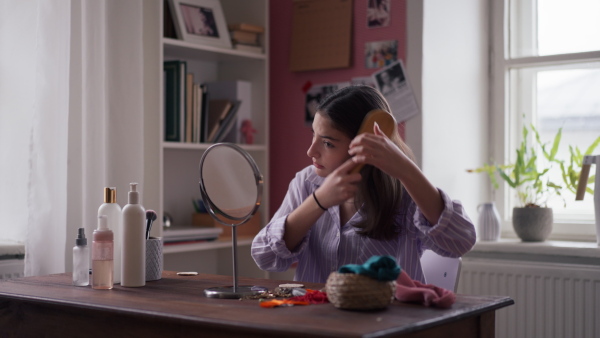 Teenage girl doing her hair care routine in the room.