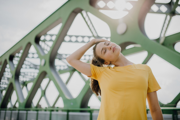 Young woman doing stretching in a city, preparing for run, healthy lifestyle and sport concept.