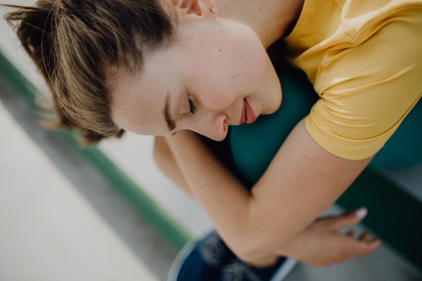 Portrait of young sportive woman resting outdoor in a city.