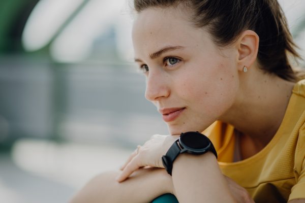 Portrait of young sportive woman outdoor in a city.