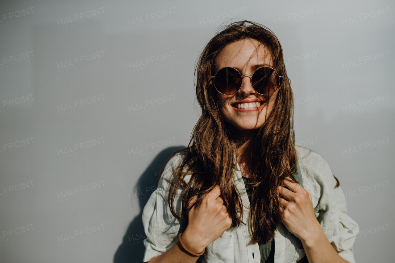 Portrait of happy young woman outdoor with a backpack and sunglasses.