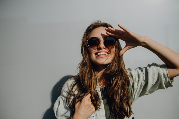 Portrait of happy young woman outdoor with a backpack and sunglasses.