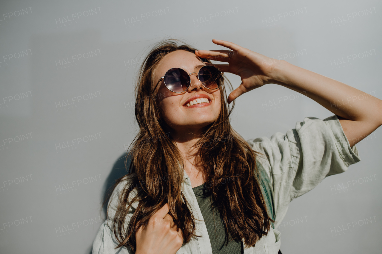 Portrait of happy young woman outdoor with a backpack and sunglasses.