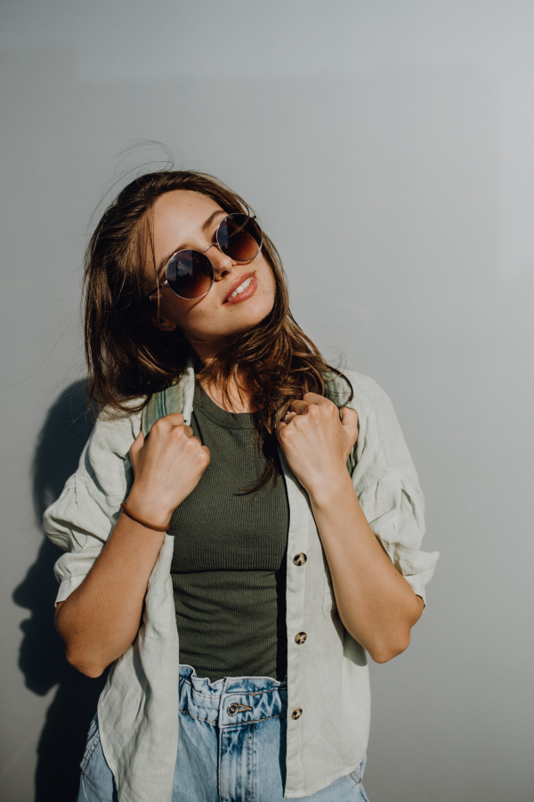 Portrait of happy young woman outdoor with a backpack and sunglasses.