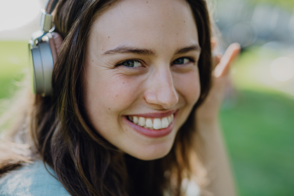 Portrait of young woman listening the music trough headphones.