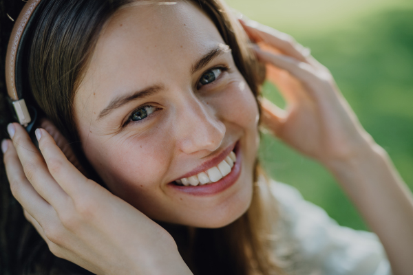 Portrait of young woman listening the music trough headphones.