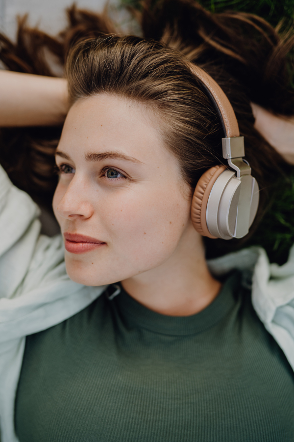 Portrait of young woman listening the music trough headphones.