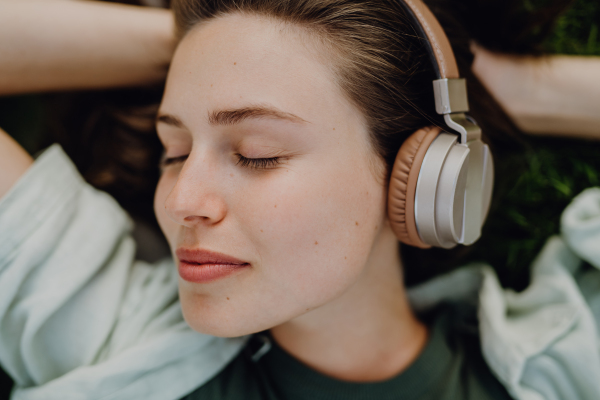 Portrait of young woman listening the music trough headphones.