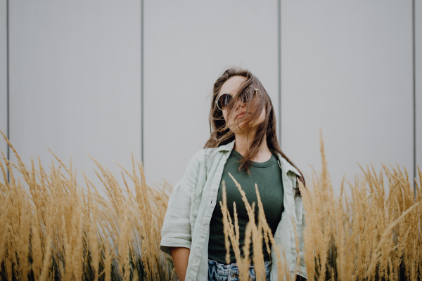 Portrait of happy young woman outdoor in city park with a sunglasses.