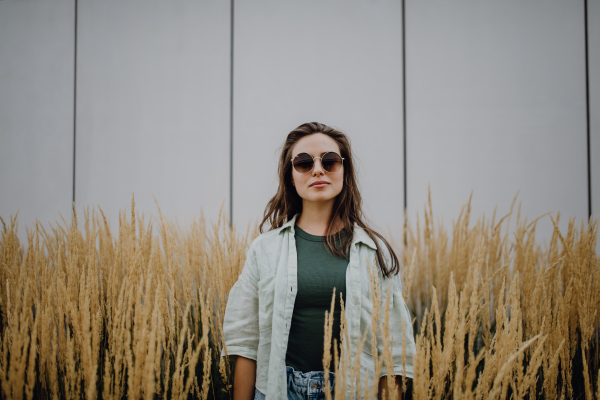 Portrait of happy young woman outdoor in city park with a sunglasses.