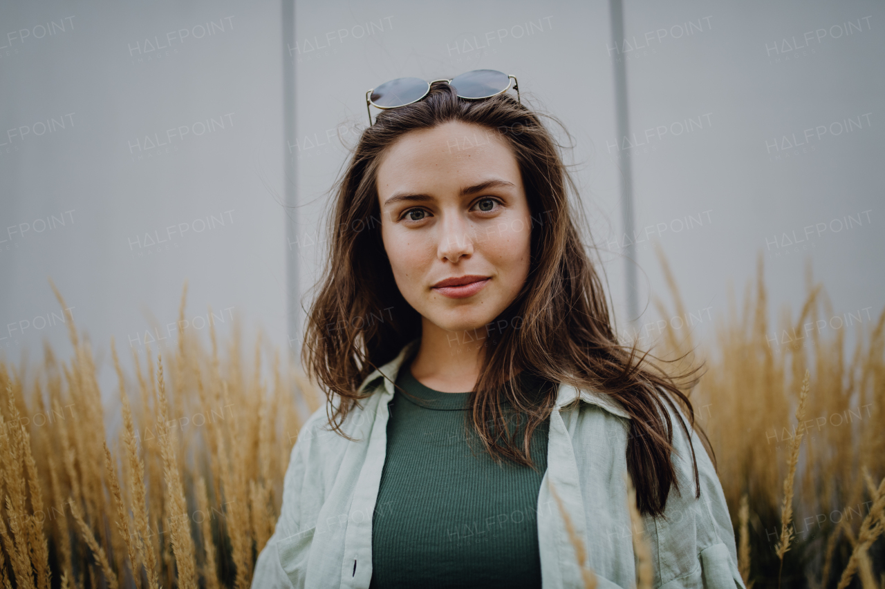 Portrait of happy young woman outdoor in city park with a sunglasses.