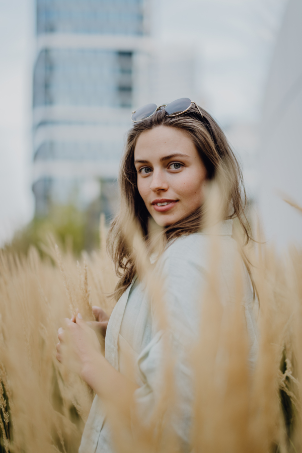 Portrait of happy young woman outdoor in city park with a sunglasses.