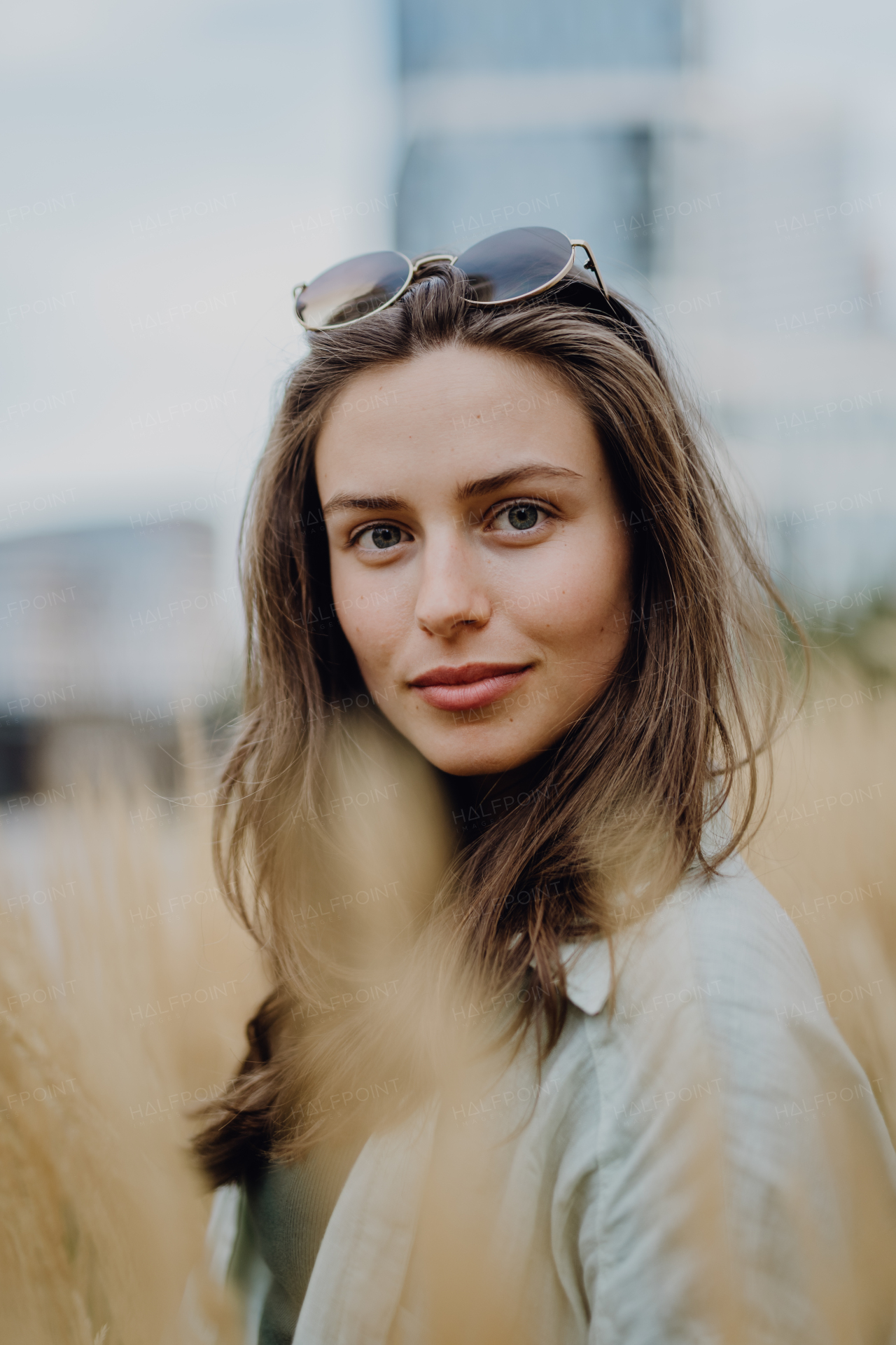 Portrait of happy young woman outdoor in city park with a sunglasses.