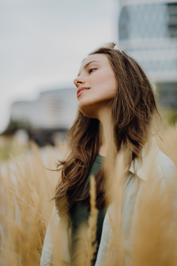 Portrait of happy young woman outdoor in city park with a sunglasses.