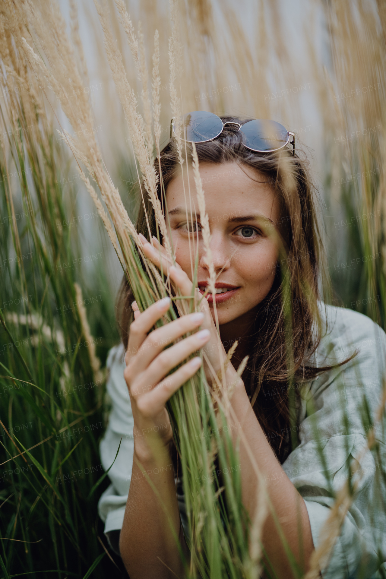 Portrait of young beautiful woman posing in a grass.