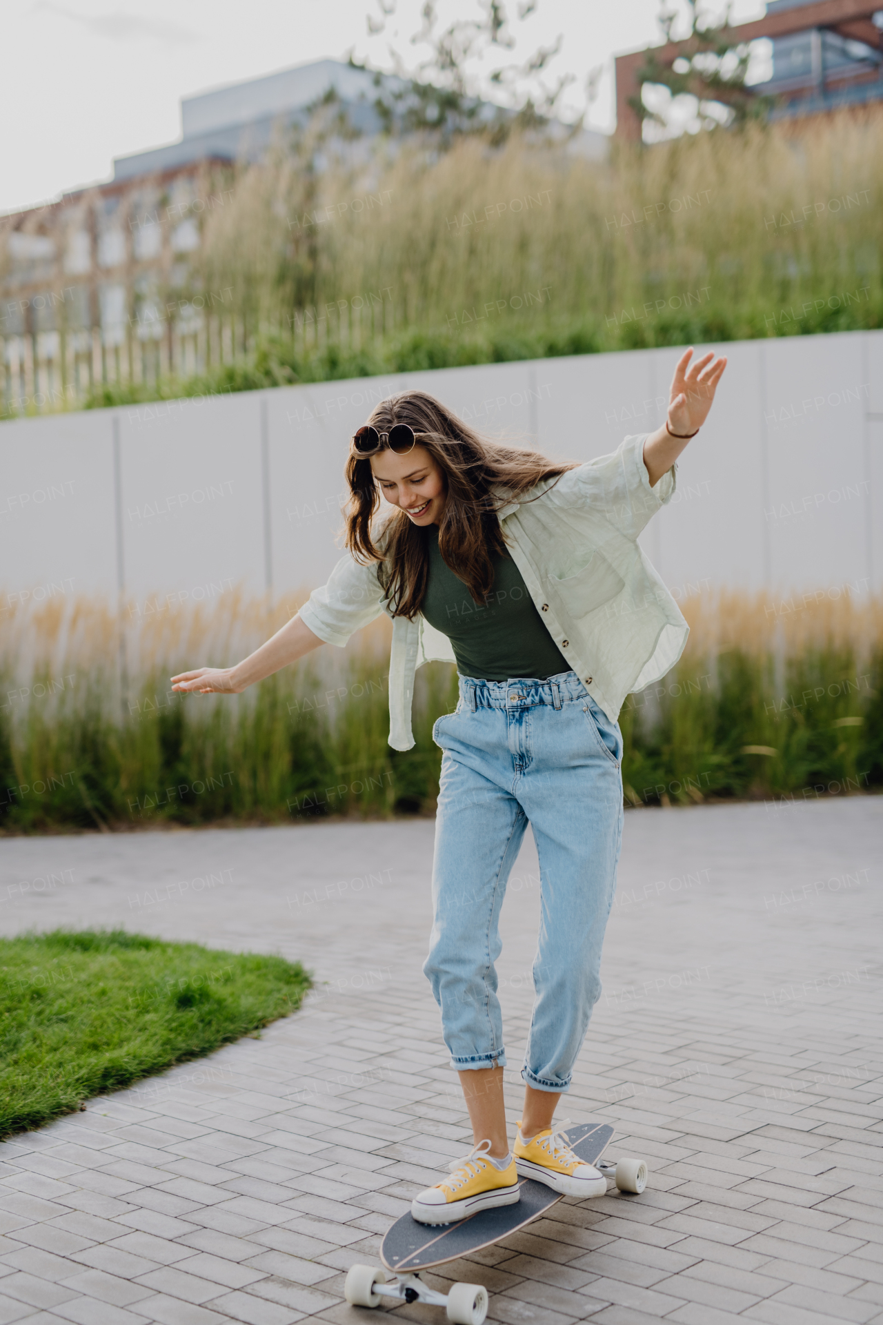 Young woman ridding a skateboard in a city. Youth culture and commuting concept.