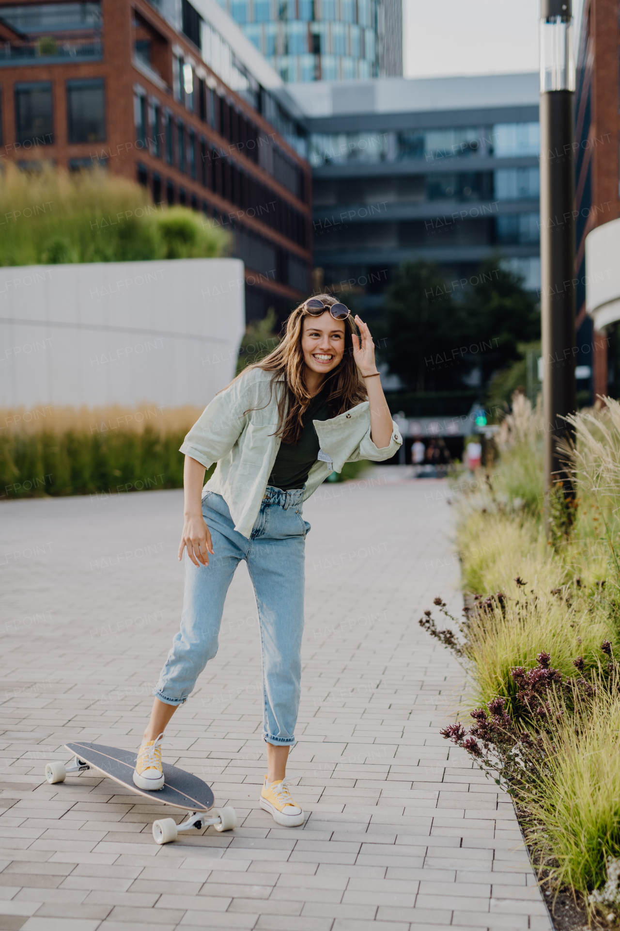 Young woman ridding a skateboard in a city. Youth culture and commuting concept.