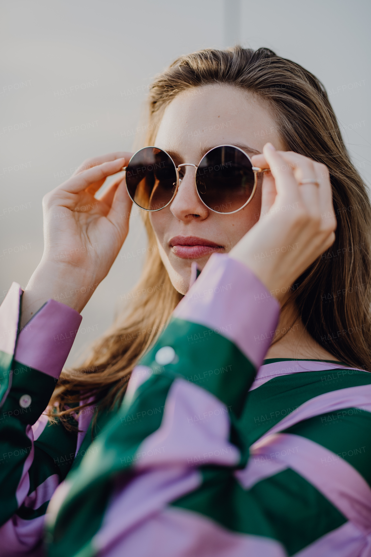 Portrait of beautiful young woman outdoor in a city, during sunset.