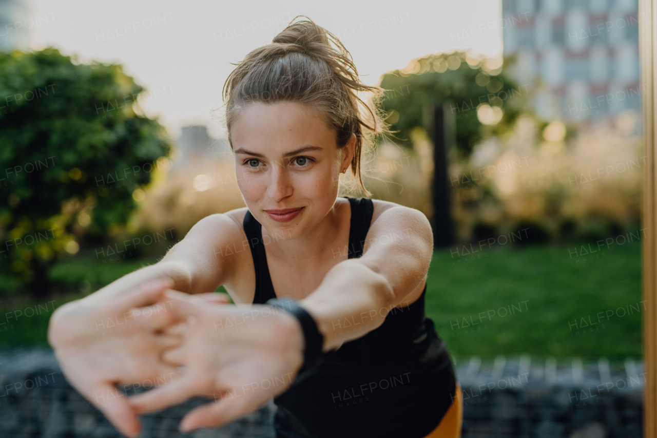 Young woman doing stretching in a city, preparing for run, healthy lifestyle and sport concept.