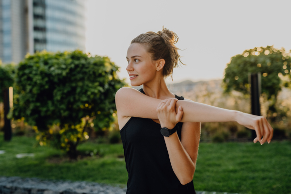 Young woman doing stretching in a city, preparing for run, healthy lifestyle and sport concept.