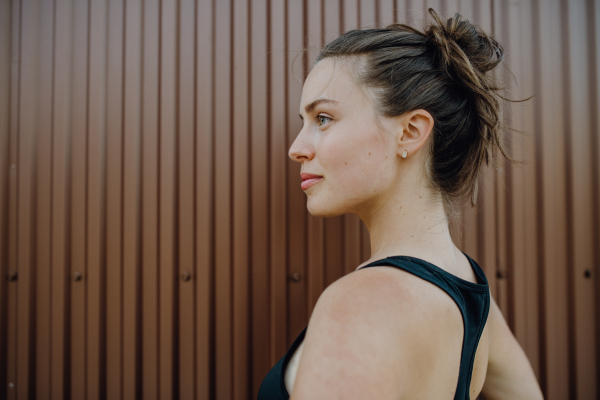 Portrait of young sportive woman outdoor in a city.