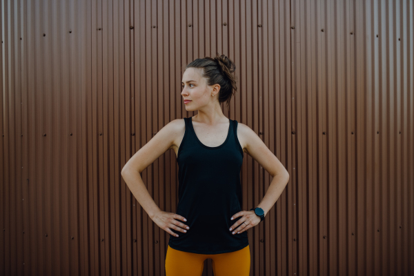 Portrait of young sportive woman outdoor in a city.