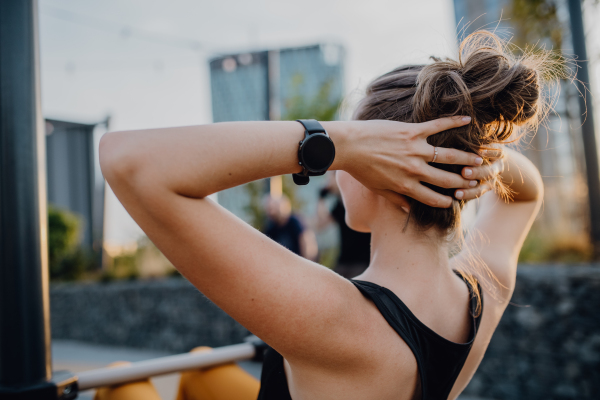 Happy young woman doing exercises at outdoor work-out city park.