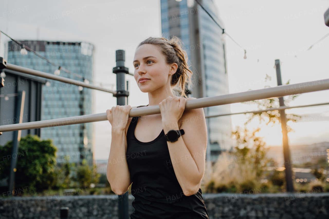 Happy young woman doing exercises at outdoor work-out city park.