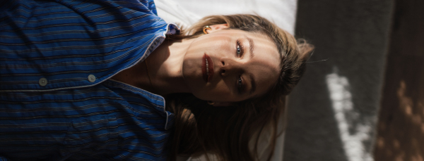 Top view of woman lying in a bed,morning sun shining on her face.