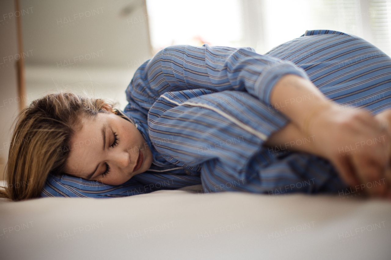 Young woman lying alone in a bed, concept of mental health.