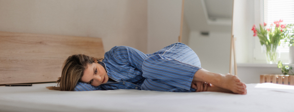 Young woman lying alone in a bed, concept of mental health.