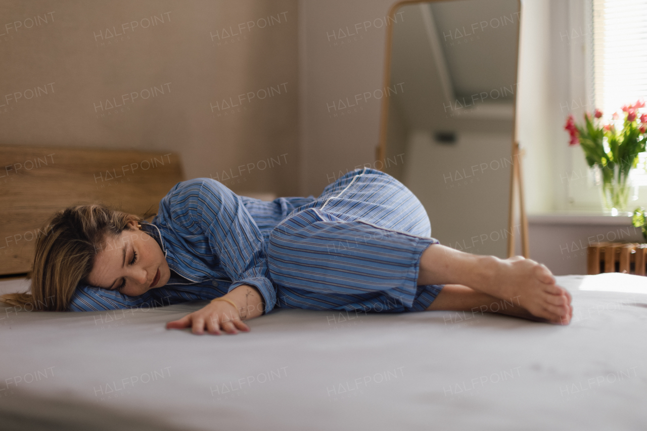 Young woman lying alone in a bed, concept of mental health.