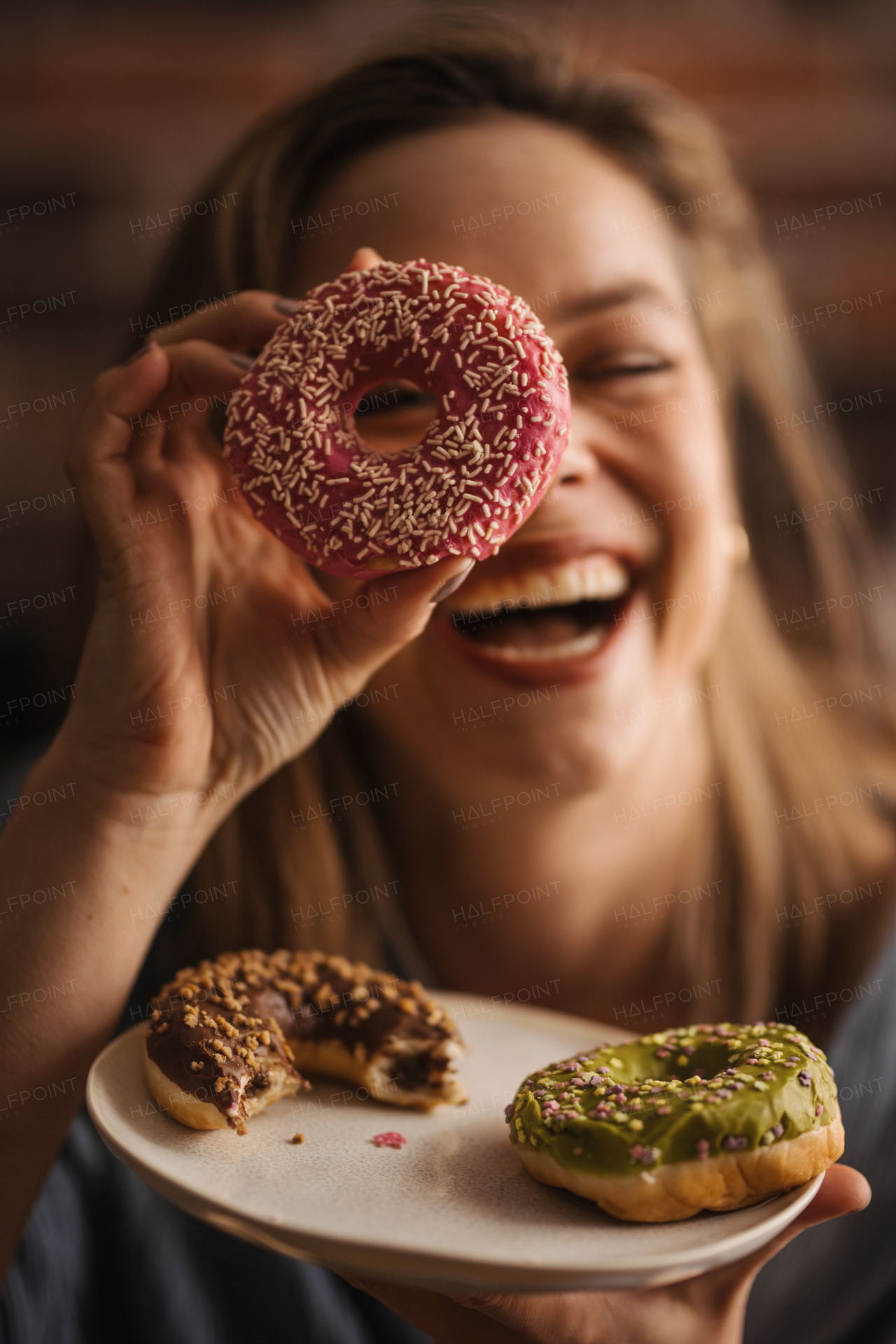 Young happy woman posing with donuts in the cafe.